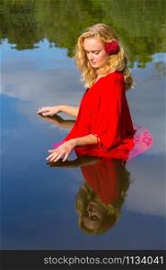 Portrait young blonde caucasian woman standing in lake