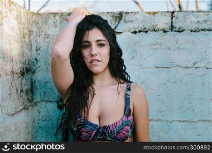 Portrait young brunette woman with bikini in an old empty pool