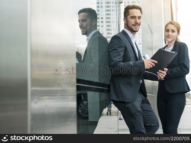 portrait young businessman holding folder hand standing with her female s colleague outdoors