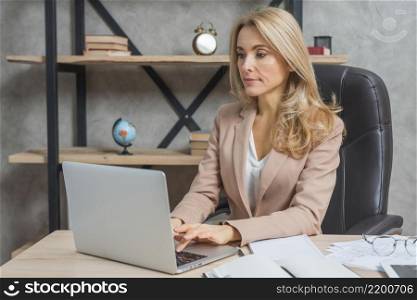 portrait young businesswoman sitting workplace using laptop office