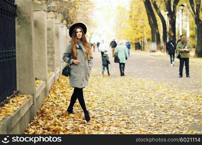 Portrait young elegant woman in grey coat and black hat. Fashion outdoors shot, street style concept. Blogger outfiit.