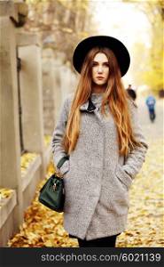 Portrait young elegant woman in grey coat and black hat. Fashion outdoors shot, street style concept. Blogger outfiit.
