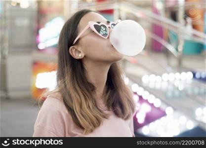 portrait young girl blowing bubble gum