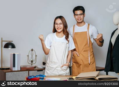 Portrait Young handsome man and pretty woman, Couple fashion designer working with scissor cutting on paper clothing pattern at the studio at home