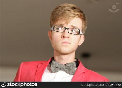Portrait young handsome stylish man fashion model in glasses wearning bright red jacket and bow tie posing indoor