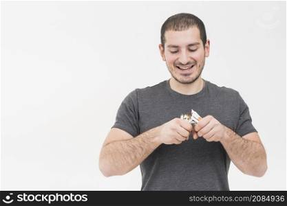 portrait young man breaking heap cigarettes isolated white background