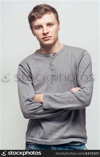 Portrait young man standing with arms crossed