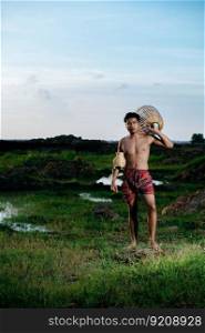 Portrait Young man topless wearing loinclothes in rural lifestyle standing with bamboo fishing trap to catch fish or shrimp for cooking