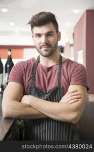 portrait young man wearing apron standing bar