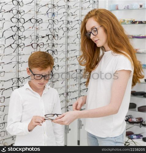 portrait young woman giving spectacle her brother optics store