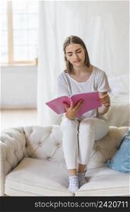 portrait young woman reading book home