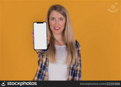 portrait young woman showing her mobile phone against orange background
