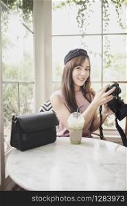 portrait younger asian woman relaxing holding dslr camera in hand