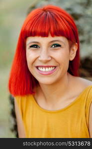 Portratif of red haired woman with yellow dress relaxed in a park