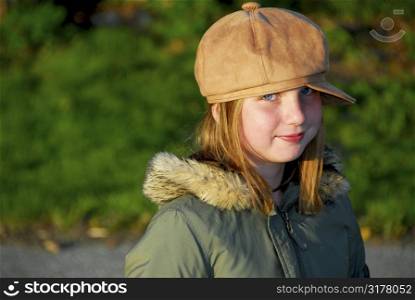 Portriat of a young smiling girl in winter or fall clothes outside