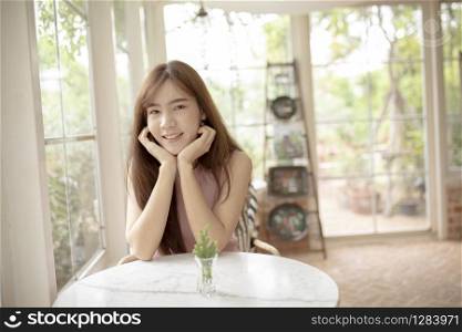 portriat of younger asian woman toothy smiling face with happiness emotion sitting in living room
