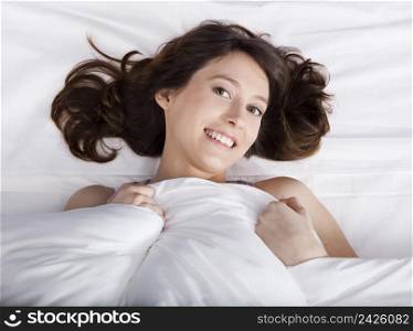 Porttrait of a beautiful and natural young girl on the bed