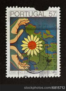 PORTUGAL - 1987: Stamp printed in Portugal shows a map of europe with a flower an hands, 1987
