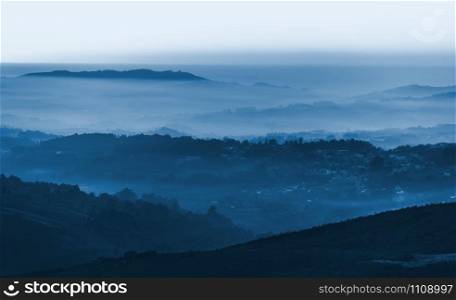Portugal landscape with layers of foggy mountains. Color of the year 2020 classic blue toned layout
