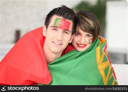 Portuguese soccer fans wrapped in flag