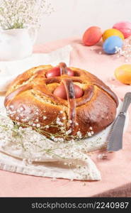 Portuguese traditional Easter cake. Folar with eggs on easter table. Blossom flowers and colorful painted eggs