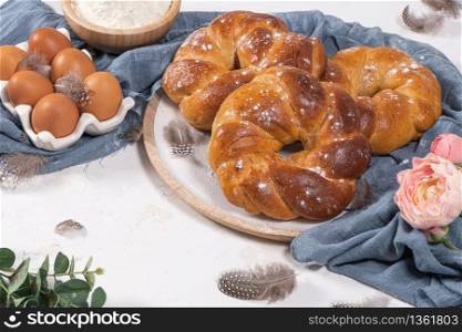 Portuguese traditional Easter cake. Folar with eggs on wooden table. Sweet bread