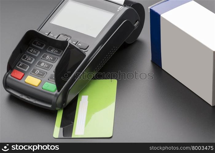 POS terminal, credit card and pill box on black background