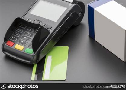 POS terminal, credit card and pill box on black background