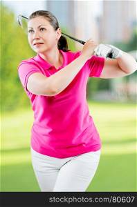 Pose woman golfer after hitting a ball club on a background of golf courses