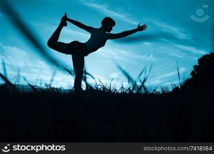 Pose yoga sunset in the field slim athletic girl