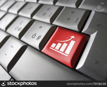 Positive business growth concept with growing bar graph and arrow icon and symbol on a red laptop computer key for Internet and online business.