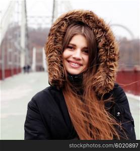 Positive emotion woman face. Happy girl smiling and enjoying view over bridge, outdoors, winter time