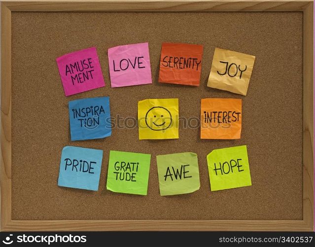 positive emotions concept - color sticky notes around smiley on cork bulletin board