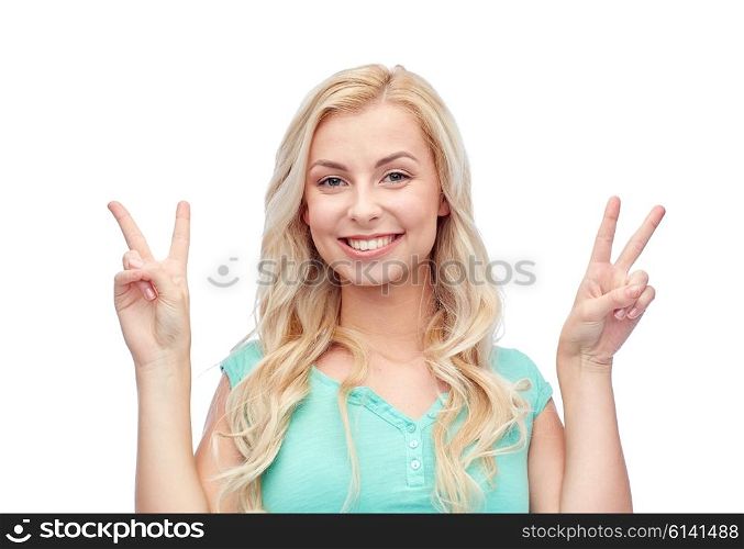 positive gesture and people concept - smiling young woman or teenage girl showing peace hand sign with both hands. smiling young woman or teenage girl showing peace
