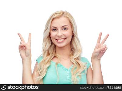 positive gesture and people concept - smiling young woman or teenage girl showing peace hand sign with both hands. smiling young woman or teenage girl showing peace