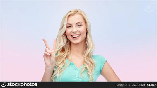 positive gesture and people concept - smiling young woman or teenage girl showing peace hand sign over pink background. smiling young woman or teenage girl showing peace