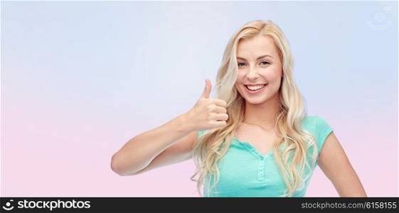 positive gesture and people concept - smiling young woman or teenage girl showing thumbs up over pink background. happy woman or teenage girl showing thumbs up