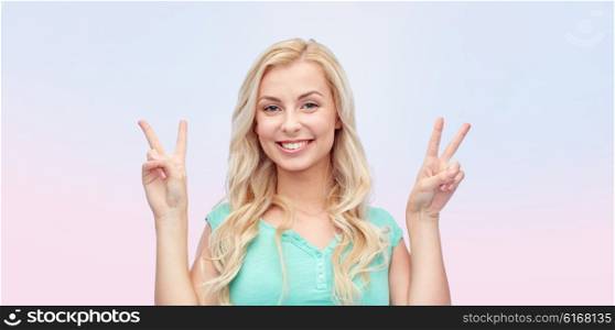 positive gesture and people concept - smiling young woman or teenage girl showing peace hand sign with both hands over rose quartz and serenity gradient background. smiling young woman or teenage girl showing peace