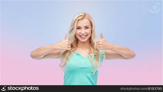 positive gesture and people concept - smiling young woman or teenage girl showing thumbs up with both hands over rose quartz and serenity gradient background. happy woman or teenage girl showing thumbs up