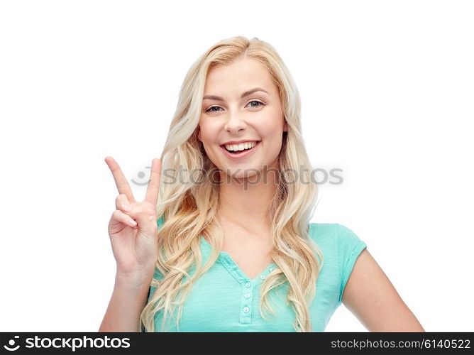 positive gesture and people concept - smiling young woman or teenage girl showing peace hand sign. smiling young woman or teenage girl showing peace