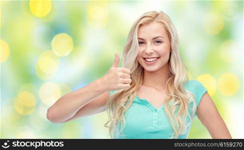 positive gesture, summer and people concept - smiling young woman or teenage girl showing thumbs up over green lights background