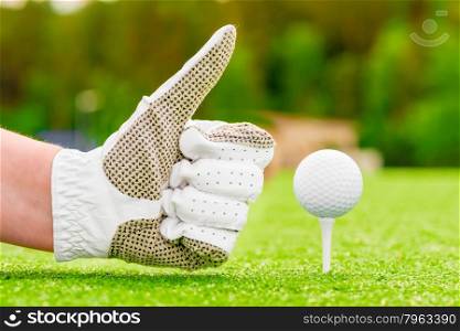 Positive hand gesture near the golf ball on a tee