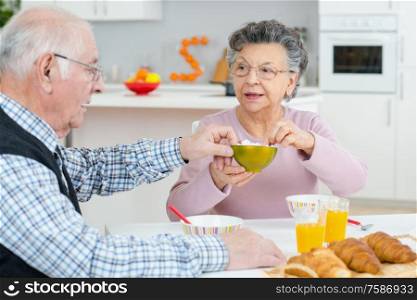 positive loving aged coupel having breakfast