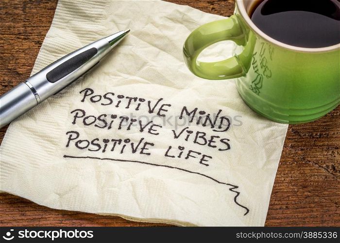 positive mind, positive vibes, positive life - motivational handwriting on a napkin with a cup of coffee