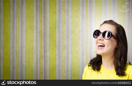 Positive teenager. Young girl teenager in sunglasses and yellow shirt