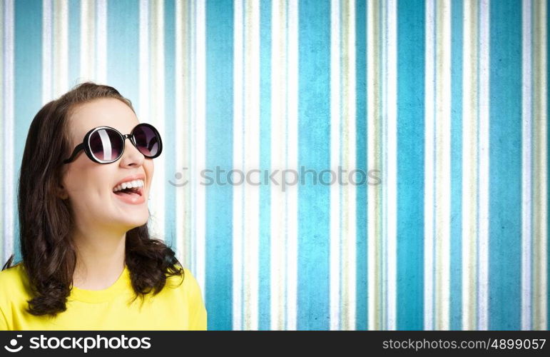 Positive teenager. Young girl teenager in sunglasses and yellow shirt