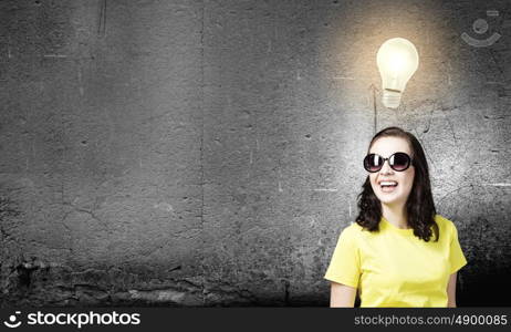 Positive teenager. Young girl teenager in sunglasses and yellow shirt