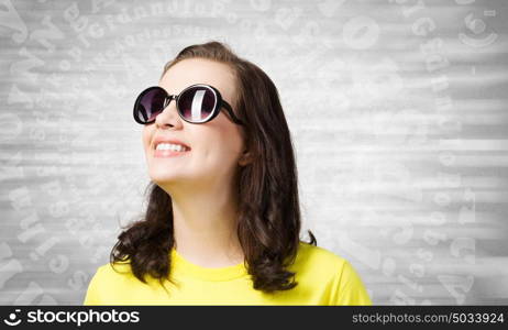 Positive teenager. Young girl teenager in sunglasses and yellow shirt