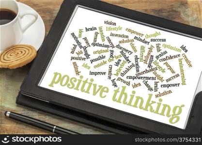 positive thinking word cloud on a digital tablet with a cup of coffee