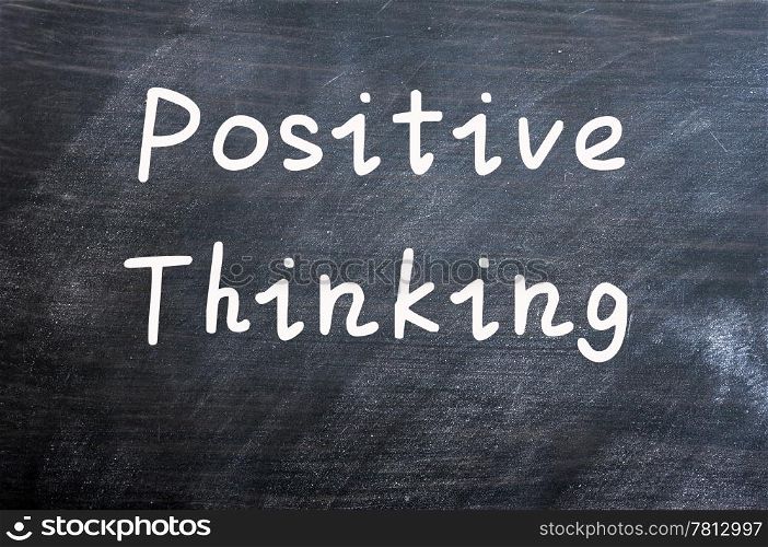 Positive thinking written with white chalk on a smudged blackboard background
